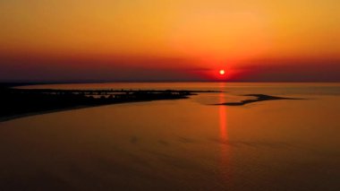4K UHD Hava Aracı Manzarası Tropikal sahilde gün batımı bulutlu denizin ortasında