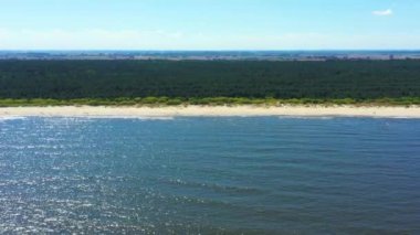 4K Aerial Manzaralı İHA beyaz kumlu güzel güncel plajı hareket ettirir. Üst manzara boş ve temiz plaj. Güzel Jantar, Mikoszewo plajı ünlü bir turizm merkezidir.