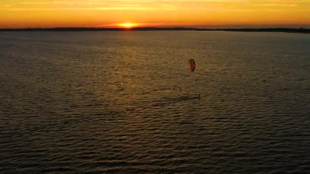 Widok z lotu ptaka młodzież surfująca na Morzu Bałtyckim, Gdańsk. W Polsce. Drone widok na ocean i ludzi zaangażowanych w sporty ekstremalne, kitesurfing. Lato Zabawa Akcja Sport. Zachód słońca — Wideo stockowe