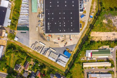 Malzeme deposunun havadan görüntüsü. Sanayi bölgesindeki lojistik dağıtım merkezi yukarıdan. Lojistik merkezde yüklenen kamyonların hava görüntüsü. İnsansız hava aracından görüntüle.