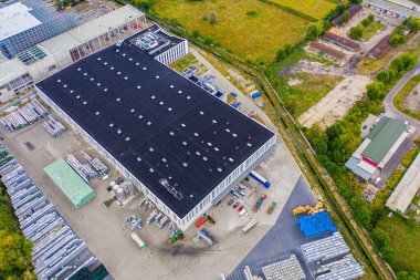 Malzeme deposunun havadan görüntüsü. Sanayi bölgesindeki lojistik dağıtım merkezi yukarıdan. Lojistik merkezde yüklenen kamyonların hava görüntüsü. İnsansız hava aracından görüntüle.