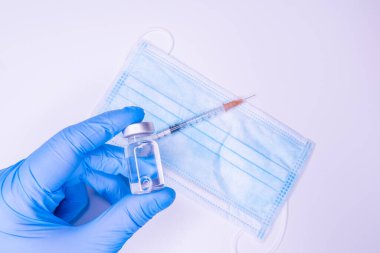 Covid 19 aşısı, dokunulmazlık ve tıbbi tedavi konsepti. Coronavirus şırıngası ve iğne. Doktor ya da hemşire maske takıyor. Corona virüsü araştırmayı vurdu. NCOV salgını.