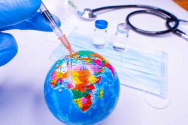 Tıbbi el Dünya 'ya aşı enjekte ediyor. Koronavirüse karşı tüm insanlar için tedavi kavramı. Seçici odak.