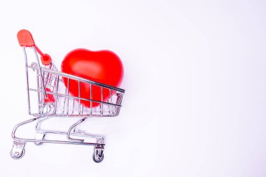 Beyaz arka planda izole edilmiş alışveriş arabasında büyük bir kalp hediyesi. Sağlık konsepti. Sağlıklı alışveriş