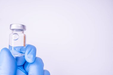 Elinde enjeksiyon için ilaç şişesi, bir doktorun avucunda. Aşı için tıbbi cam şişe. Bilim ekipmanları, sıvı ilaç veya aşısı, laboratuvarda, hastanede veya eczanede grip.