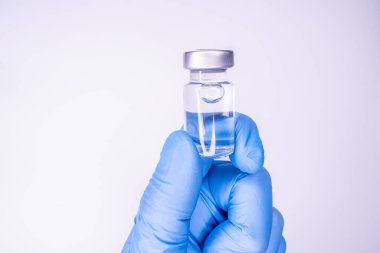 Elinde enjeksiyon için ilaç şişesi, bir doktorun avucunda. Aşı için tıbbi cam şişe. Bilim ekipmanları, sıvı ilaç veya aşısı, laboratuvarda, hastanede veya eczanede grip.