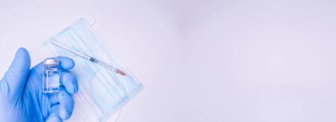 Covid 19 aşısı, dokunulmazlık ve tıbbi tedavi konsepti. Coronavirus şırıngası ve iğne. Doktor ya da hemşire maske takıyor. Corona virüsü araştırmayı vurdu. NCOV salgını. Boşluğu Kopyala