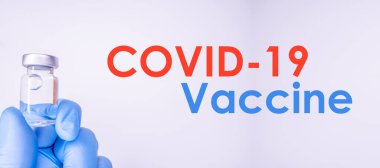 Omzunda steteskop olan kadın doktor şırınga ve COVID-19 aşısı. Sağlık ve Tıp Konsepti.