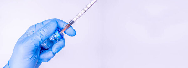 Syringe in a hand of a doctor or nurse and medicine or vaccine vial. Vaccination and immunization concept. Medicine and health care. Vaccine trials and research. Pharmacy. COpy space Copy Space