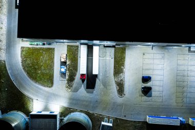 Malzeme deposunun Gece Havası görüntüsü. Sanayi bölgesindeki lojistik merkezi yukarıdan. Lojistik merkezde yüklenen kamyonların hava görüntüsü. İnsansız hava aracından görüntüle.