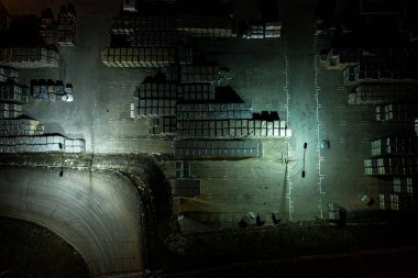 Malzeme deposunun Gece Havası görüntüsü. Sanayi bölgesindeki lojistik merkezi yukarıdan. Lojistik merkezde yüklenen kamyonların hava görüntüsü. İnsansız hava aracından görüntüle.