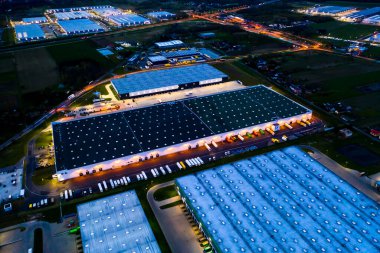 Mal depolama gecesinin hava görüntüsü. Sanayi bölgesindeki lojistik merkezi yukarıdan. Lojistik merkezde yüklenen kamyonların hava görüntüsü