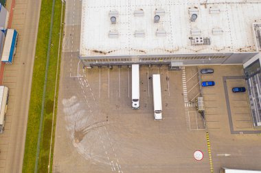 Malzeme deposunun havadan görüntüsü. Lojistik dağıtım, sanayi bölgesinin merkezi yukarıdan. Lojistik merkezde yüklenen kamyonların hava görüntüsü. İnsansız hava aracından görüntüle.