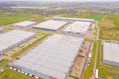 Malzeme deposunun havadan görüntüsü. Sanayi bölgesindeki lojistik merkezi yukarıdan. Lojistik merkezde yüklenen kamyonların hava görüntüsü. İnsansız hava aracından görüntüle.