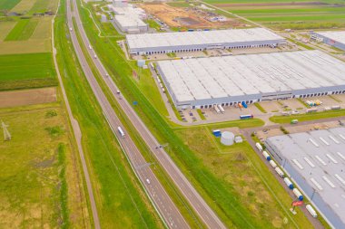 Malzeme deposunun havadan görüntüsü. Sanayi bölgesindeki lojistik merkezi yukarıdan. Lojistik merkezde yüklenen kamyonların hava görüntüsü. İnsansız hava aracından görüntüle.