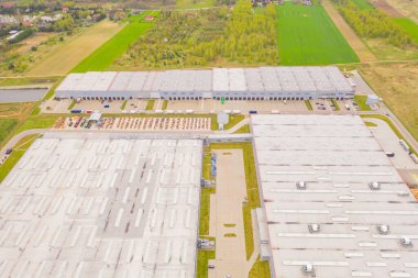 Malzeme deposunun havadan görüntüsü. Sanayi bölgesindeki lojistik merkezi yukarıdan. Lojistik merkezde yüklenen kamyonların hava görüntüsü. İnsansız hava aracından görüntüle.