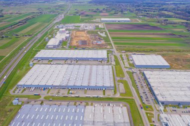 Malzeme deposunun havadan görüntüsü. Sanayi bölgesindeki lojistik merkezi yukarıdan. Lojistik merkezde yüklenen kamyonların hava görüntüsü. İnsansız hava aracından görüntüle.