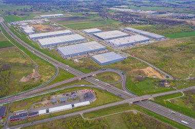 Malzeme deposunun havadan görüntüsü. Sanayi bölgesindeki lojistik merkezi yukarıdan. Lojistik merkezde yüklenen kamyonların hava görüntüsü. İnsansız hava aracından görüntüle.