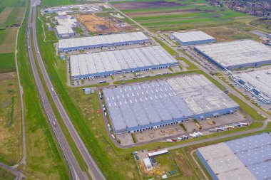 Malzeme deposunun havadan görüntüsü. Sanayi bölgesindeki lojistik merkezi yukarıdan. Lojistik merkezde yüklenen kamyonların hava görüntüsü. İnsansız hava aracından görüntüle.