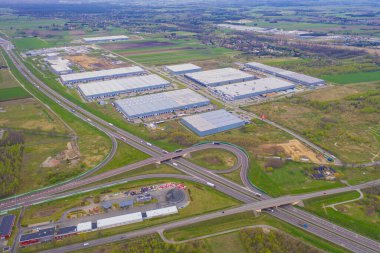 Malzeme deposunun havadan görüntüsü. Sanayi bölgesindeki lojistik merkezi yukarıdan. Lojistik merkezde yüklenen kamyonların hava görüntüsü. İnsansız hava aracından görüntüle.