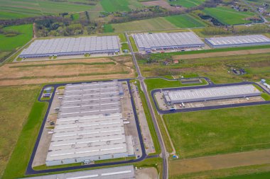 Malzeme deposunun havadan görüntüsü. Sanayi bölgesindeki lojistik merkezi yukarıdan. Lojistik merkezde yüklenen kamyonların hava görüntüsü. İnsansız hava aracından görüntüle.