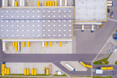 Malzeme deposunun havadan görüntüsü. Sanayi bölgesindeki lojistik merkezi yukarıdan. Lojistik merkezde yüklenen kamyonların hava görüntüsü. İnsansız hava aracından görüntüle.