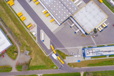 Malzeme deposunun havadan görüntüsü. Sanayi bölgesindeki lojistik merkezi yukarıdan. Lojistik merkezde yüklenen kamyonların hava görüntüsü. İnsansız hava aracından görüntüle.