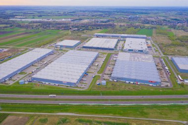Malzeme deposunun havadan görüntüsü. Sanayi bölgesindeki lojistik merkezi yukarıdan. Lojistik merkezde yüklenen kamyonların hava görüntüsü. İnsansız hava aracından görüntüle.