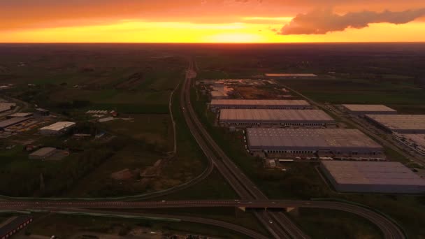 Sattelschlepper warten an den Lagerrampen in einem großen Logistikpark mit Verladebahnhof auf das Be- und Entladen der Waren. Luftaufnahme bei Sonnenuntergang — Stockvideo