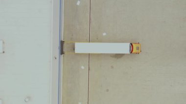 Hava görüntüsü. Mal dağıtım deposu. Yarı kamyonlar kargo konteynırlarını yüklüyor. Lojistik ihracat ve ithal kargo dağıtım nakliye merkezi. 4k İHA.