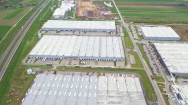 Malzeme deposunun havadan görüntüsü. Sanayi bölgesindeki lojistik merkezi yukarıdan. Lojistik merkezde yüklenen kamyonların hava görüntüsü. İnsansız hava aracından görüntüle.