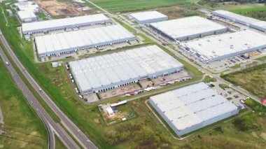 Malzeme deposunun havadan görüntüsü. Sanayi bölgesindeki lojistik merkezi yukarıdan. Lojistik merkezde yüklenen kamyonların hava görüntüsü. İnsansız hava aracından görüntüle.