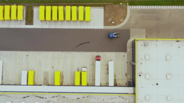 Hava görüntüsü. Mal dağıtım deposu. Yarı kamyonlar kargo konteynırlarını yüklüyor. Lojistik ihracat ve ithal kargo dağıtım nakliye merkezi. 4k İHA. — Stok video
