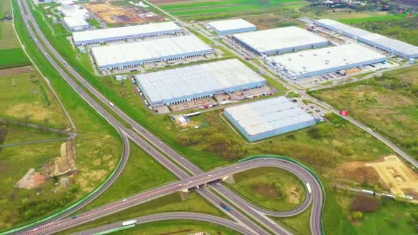 Luchtfoto van goederenmagazijn. Logistiek centrum in industriële stedelijke zone van bovenaf. Luchtfoto van vrachtwagens laden in logistiek centrum. Uitzicht vanaf drone. — Stockvideo