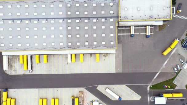 Luftaufnahme eines Industrielagers / Lagergebäudes / Ladefläche, auf der viele LKW Waren be- / entladen. Schuss mit Phantom 4K UHD-Kamera. — Stockvideo