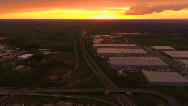 Luftaufnahme des Logistikparks mit Lager, Verladebahnhof und vielen Sattelschleppern mit Ladeanhängern, die bei Sonnenuntergang an den Rampen zum Be- und Entladen von Waren stehen — Stockvideo