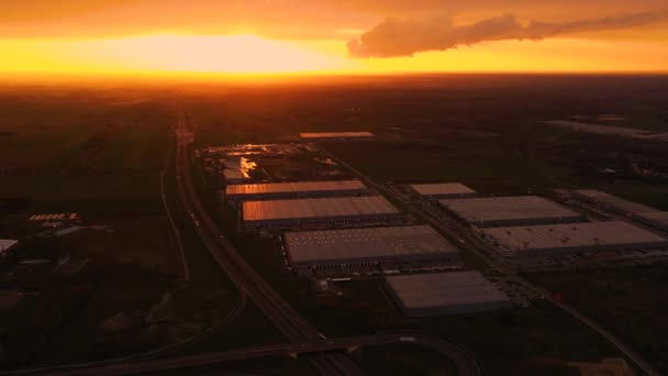 Parque logístico com hub de carregamento. Caminhões semi-reboque ficar no estacionamento e esperar para carga e descarregar mercadorias em rampas de armazém. Vista aérea ao pôr do sol — Vídeo de Stock