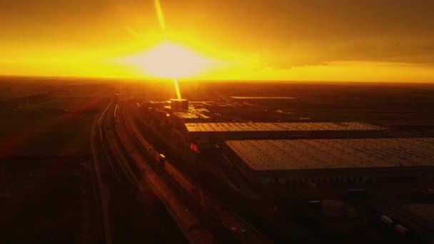 Logistikpark mit Verladebahnhof. Sattelschlepper stehen auf dem Parkplatz und warten an Lagerrampen auf das Be- und Entladen von Waren. Luftaufnahme bei Sonnenuntergang — Stockvideo