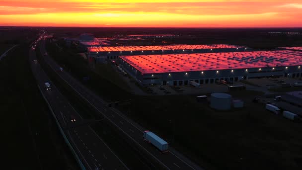 设有仓库的物流园区的空中全景、设有许多载货拖架的半卡车的装货中心，供日落时上下载货之用 — 图库视频影像