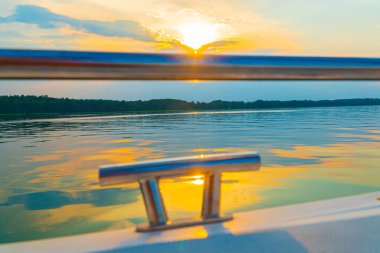 Denizde yüzen bir tekne, güzel altın bir günbatımında bir adam