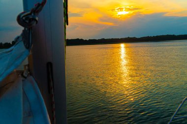 Suda yansıması olan sakin bir gölde yelken açmak. Huzurlu manzara. Dikey fotoğraf.