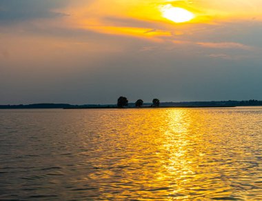 Suda yansıması olan sakin bir gölde yelken açmak. Huzurlu manzara. Dikey fotoğraf.