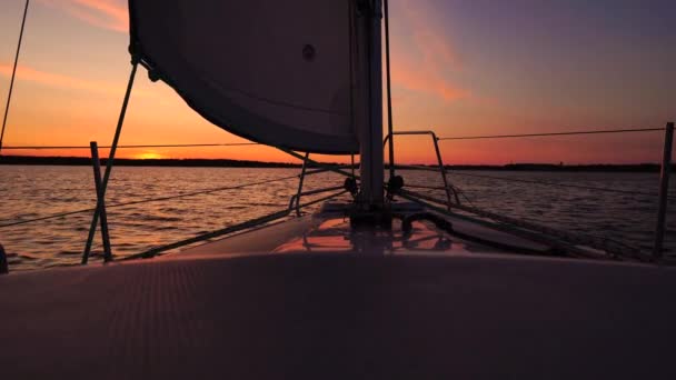 A cinematic scene of  small sailing yacht boats sailing along the golden calm waters on lake, river, sea or ocean. Beautiful sunset or sunrise, relaxation, calmness, sailing, sailors. Luxury living — Stock Video