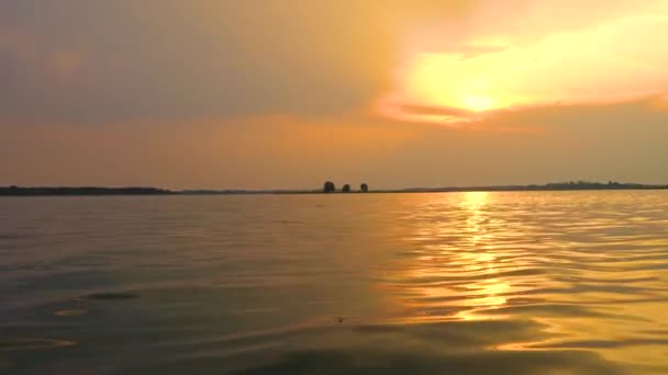 Gün batımında göl manzarası, gökyüzünde parlama ve sudaki gölün yanındaki ağaçların yansıması., — Stok video
