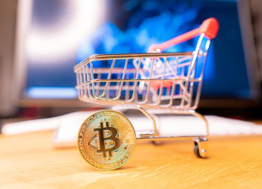 Arka plandaki bilgisayara karşı süpermarketten bir sepetteki kripto para.