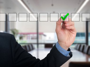 Businessman ticks off in in a square. Task list concept. Isolated on grey background.