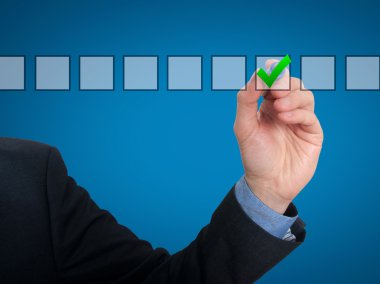 Businessman ticks off in in a square. Task list concept. Isolated on grey background.