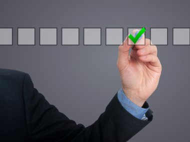 Businessman ticks off in in a square. Task list concept. Isolated on grey background.