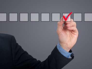 Businessman ticks off in in a square. Task list concept. Isolated on grey background.