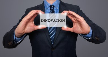 Businessman holding white card with Innovation sign - Stock Photo